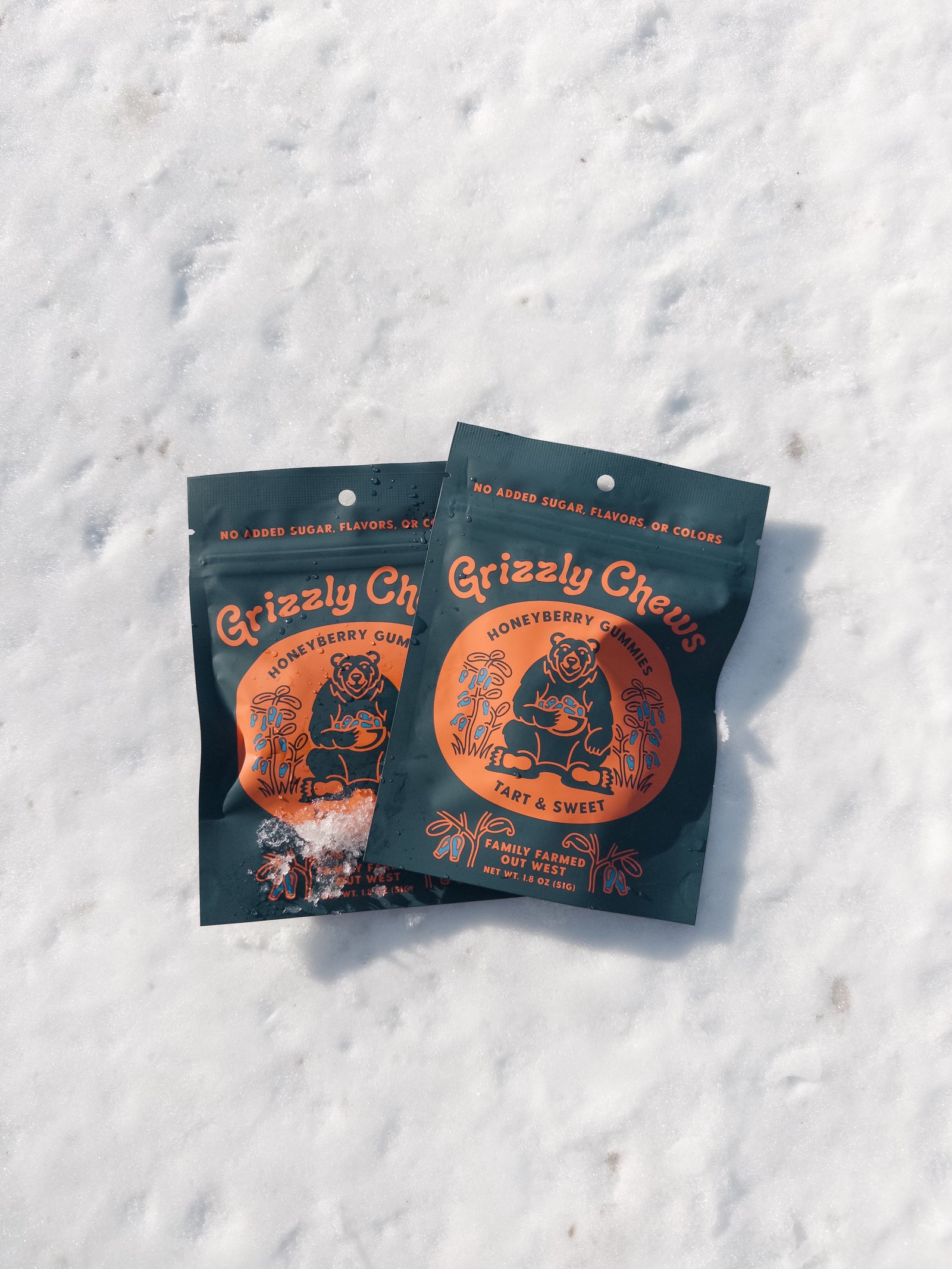 Two packages of Grizzly Chews on a snowy background